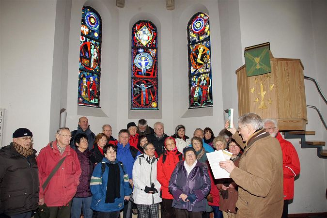 Wandergruppe vor dem Kirchenfenster 